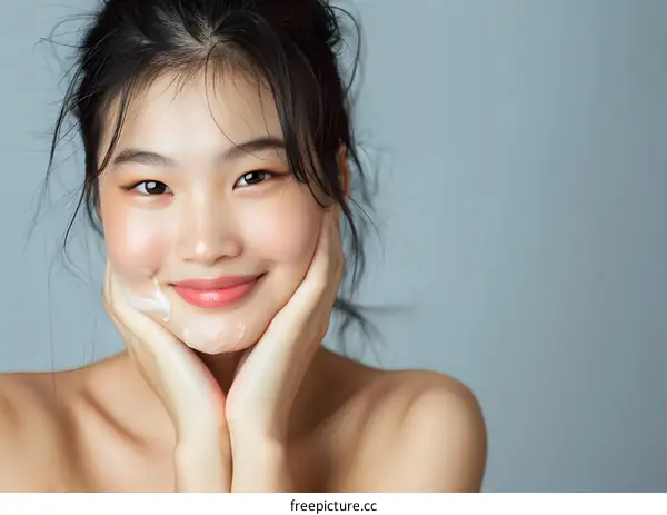 Smiling Asian Woman Applying Facial Cleanser