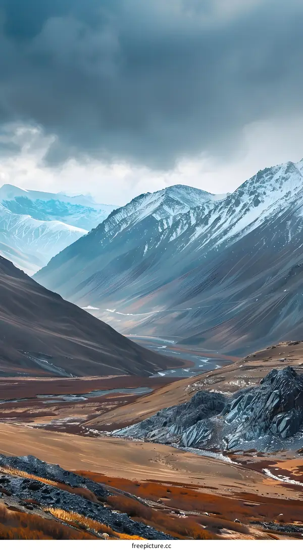 Mountain Range with Snow Covered Peaks and a River Valley