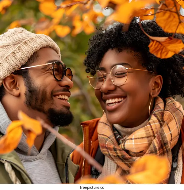 Couple laughing together in autumn leaves