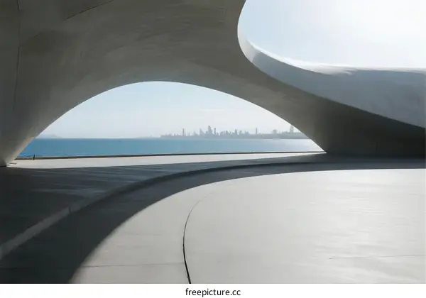 Modern curved architectural structure overlooking the sea and city skyline