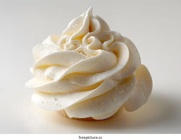 Close-up of a white frosted cupcake on a white background