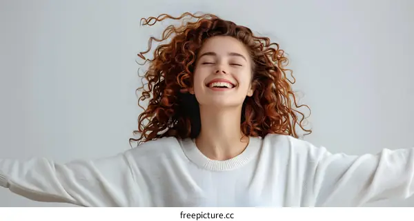 Laughing curly redhead girl with closed eyes