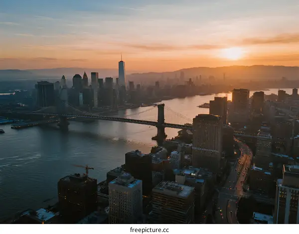 Sunset Over Modern Cityscape with River and Bridge