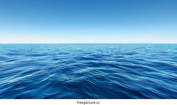 Deep blue sea with gentle waves under bright blue sky