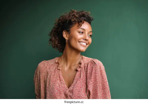 Smiling Woman in a Floral Dress against a Green Background