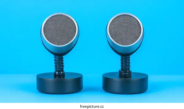 Two Modern Studio Microphones on a Blue Background