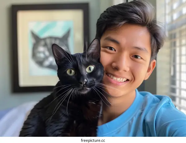 A young man with his black cat