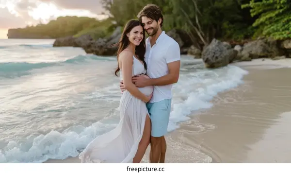 Happy pregnant couple on beach at sunset