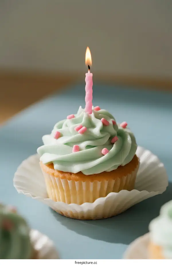 Delicious Cupcake with Green Frosting and Lit Candle