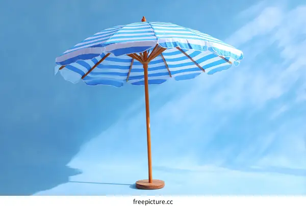 Summer Blue Striped Beach Umbrella Against a Sky Background