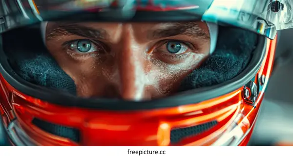 Close up portrait of a male race car driver wearing a red helmet