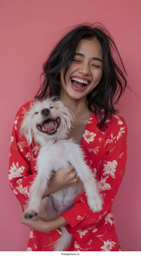 Laughing woman holding a small white dog