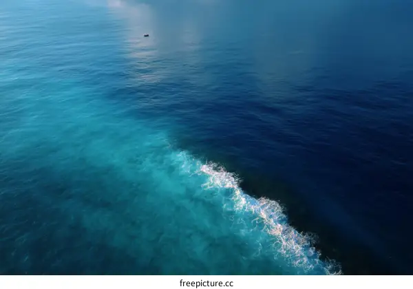 Aerial View of Turquoise and Deep Blue Ocean Waves