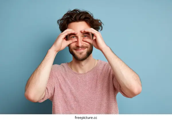 Smiling Caucasian Man Looking Through Fingers
