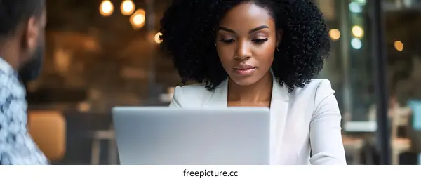 African American Businesswoman Using Laptop In Cafe