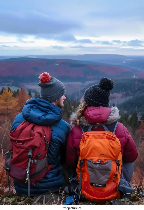 Couple Hiking in Autumn Mountains Wearing Winter Gear and Backpacks