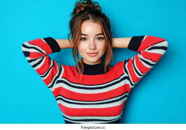 Young Woman in a Striped Sweater Against a Blue Background