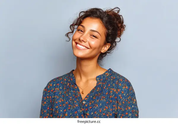 Happy Young Woman with Curly Hair in Colorful Blouse