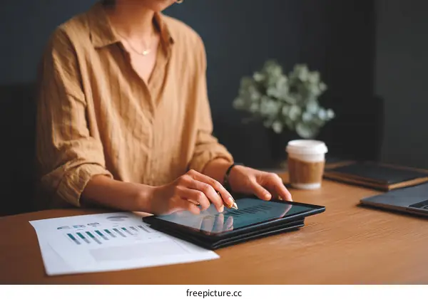 Woman Working on Digital Tablet with Business Documents