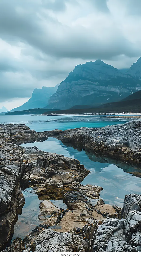 Rocky Coastline with Turquoise Water and Dramatic Mountains