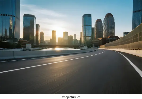 Sunset over modern cityscape with empty road ahead