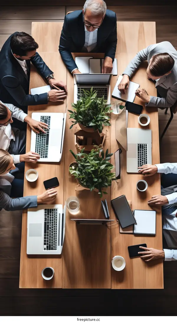 Top view of a diverse group of business professionals having a meeting around a wooden table
