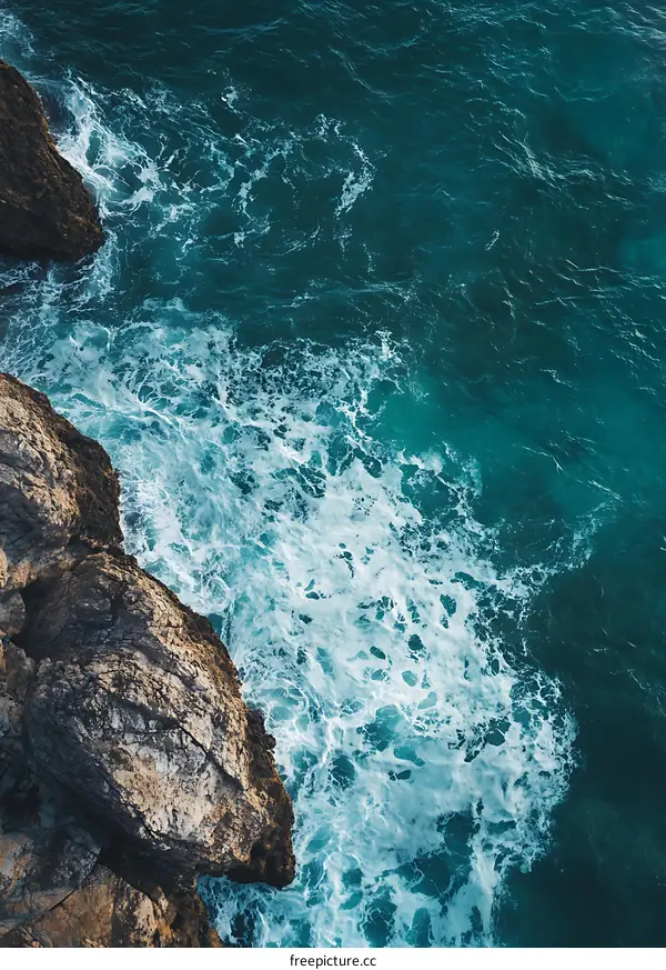 Aerial View of Rocky Coastline and Foamy Waves