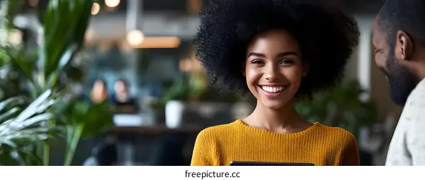 Smiling Woman with Afro Hair Looking at Man in Office