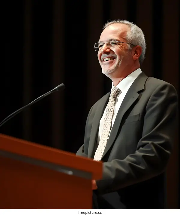 Smiling Man in Suit Speaking at a Podium