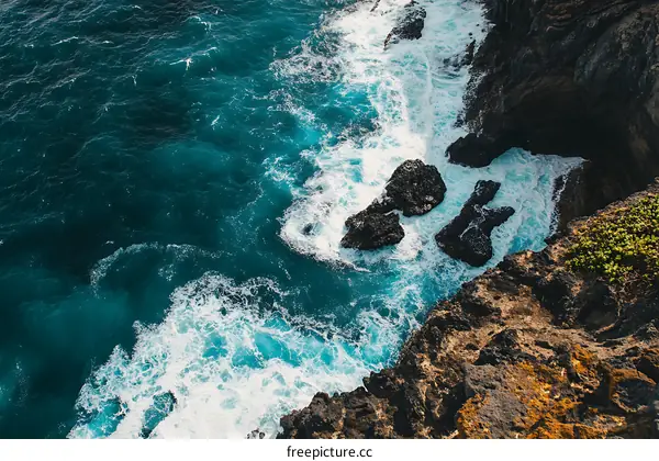Aerial View of Ocean Waves Crashing on Rocky Coast