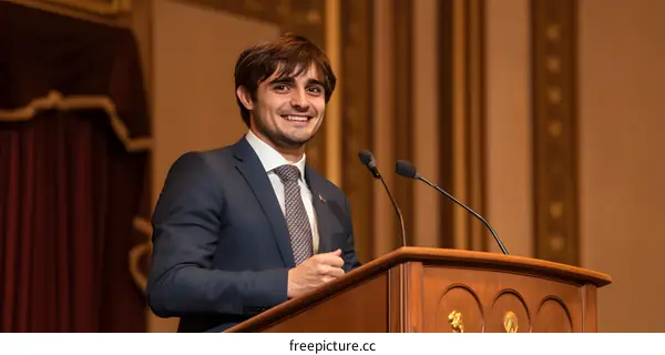 Man in Suit Speaking at Podium with Microphone