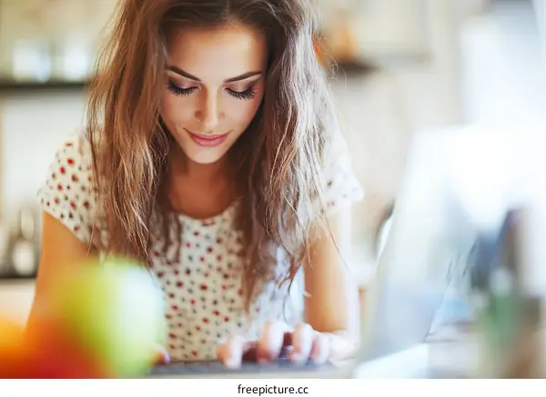 Woman Working on Laptop in Kitchen