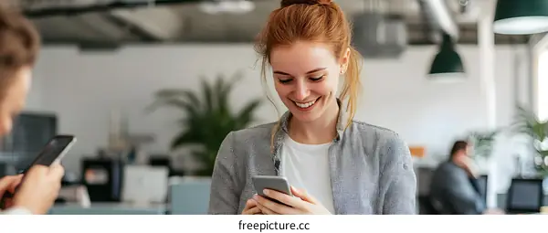 Smiling Woman Using Smartphone In Modern Office
