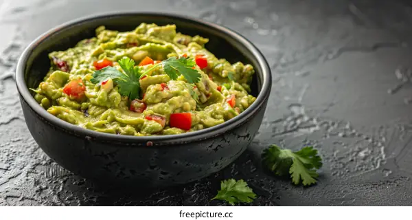 Fresh Guacamole In Dark Bowl With Cilantro and Lime