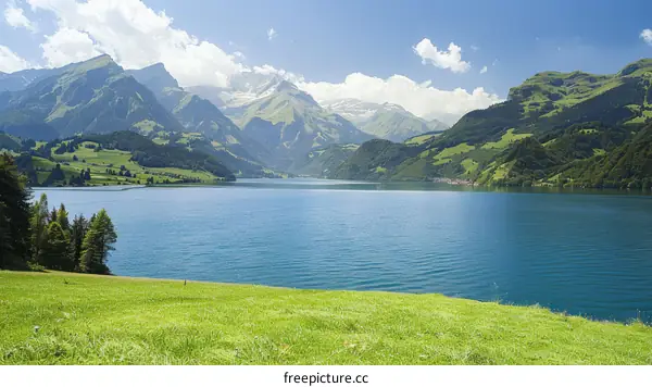 Scenic view of a mountain lake with green hills and blue sky