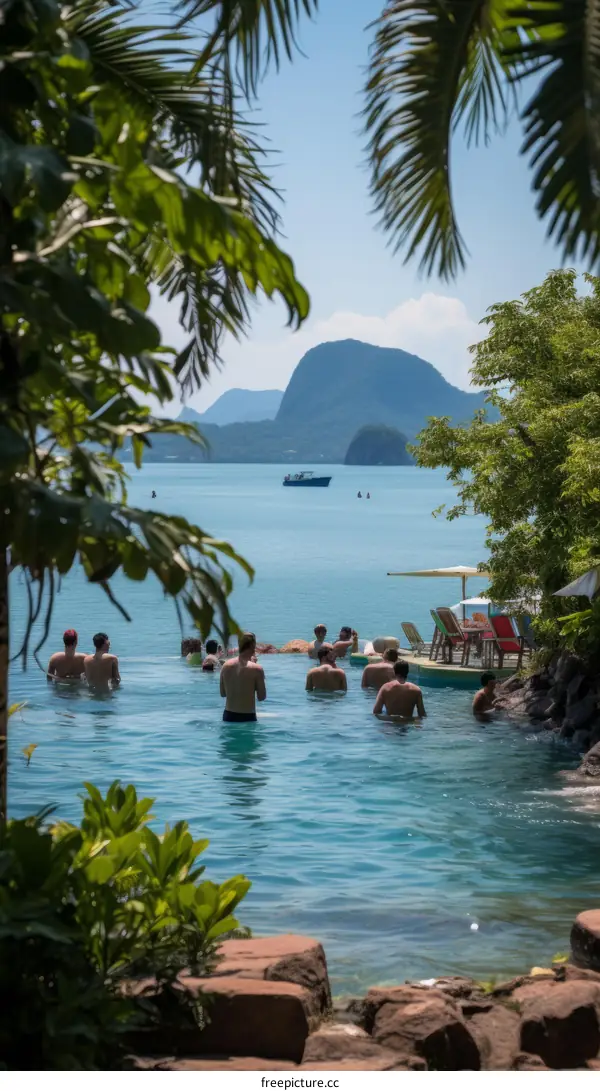 People swimming in a pool with a view of the ocean