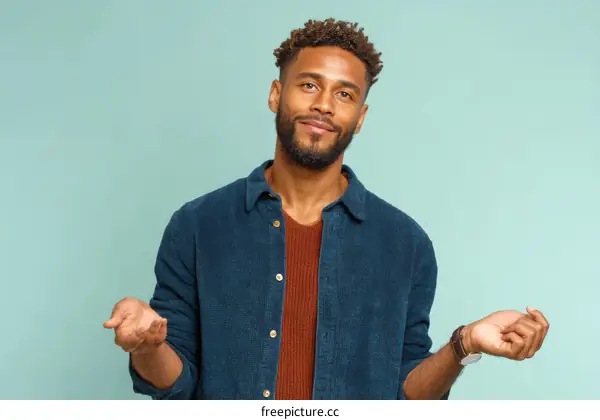 African Man Posing Against a Light Teal Background