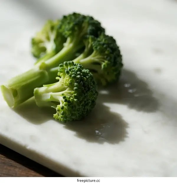 Fresh Broccoli Florets on White Marble Surface