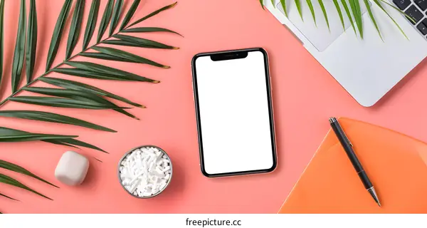 Flat Lay Composition of Phone, Laptop, Notebook, and Palm Leaves on Pink Background