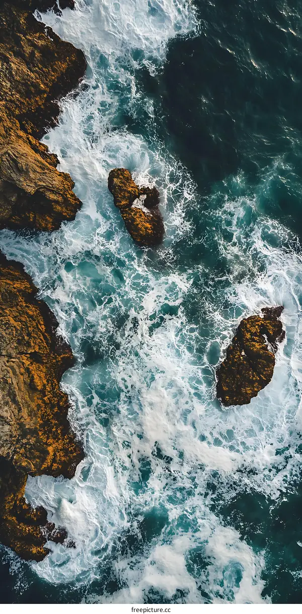 Aerial View of Ocean Waves Crashing Against Rocks