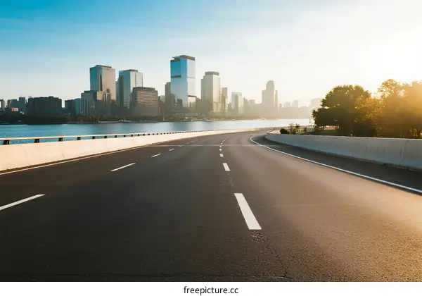 Smooth road leading to a modern city skyline under clear sky