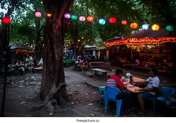 People Gathering At Outdoor Cafe Under String Lights