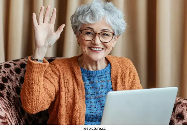 Smiling Senior Woman Waving Hello with Laptop