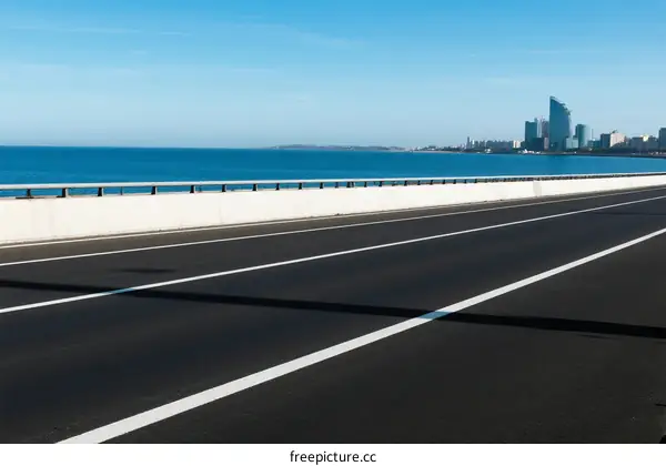 Smooth asphalt road along the seaside with clear blue sky