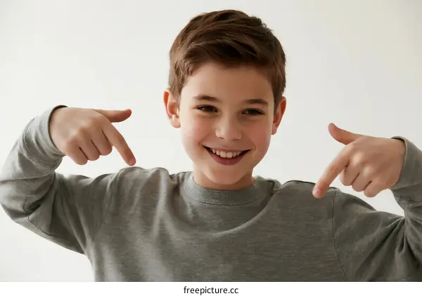 Young boy pointing at himself with a happy expression