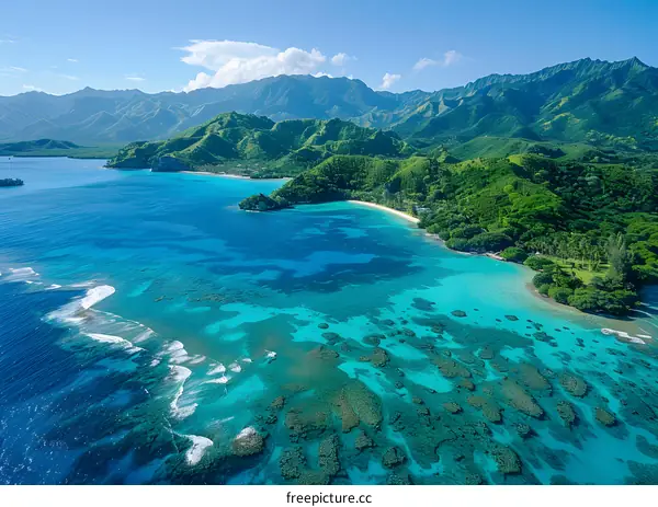 Aerial view of a tropical island with green mountains, blue water and coral reef