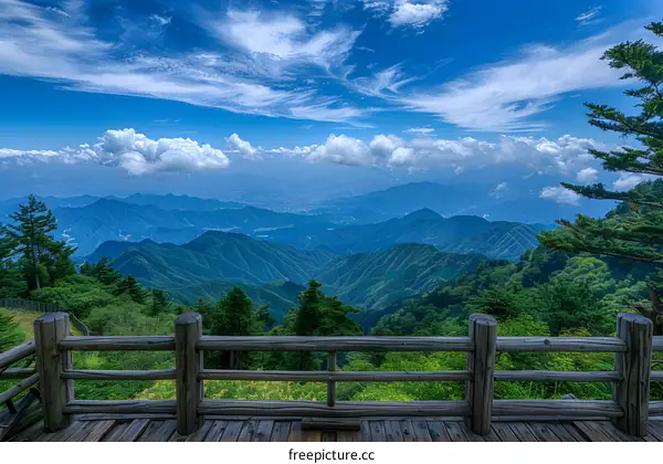 A view of mountains from a wooden observation deck.