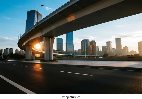 Urban overpass with city skyline under sunrise light