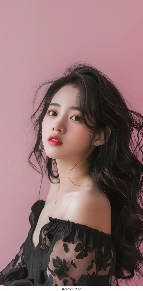 Portrait of a Young Woman in a Black Lace Dress Against a Pink Background