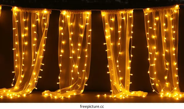 Yellow fairy lights hanging on a black background